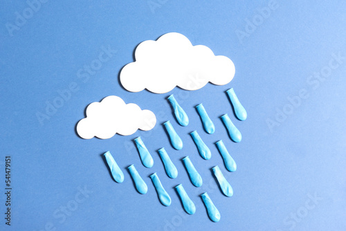 rain with white clouds and drops made with balloon, on blue background
