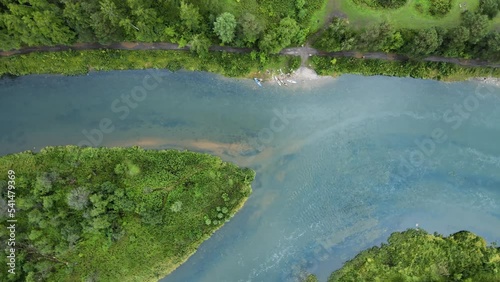 Top view of a tourists group on kayaks. The drone turns over river and the island. Nature of the Ural Mountains. Sports tourism and active recreation on the water. Cinematic footage of a fast flow