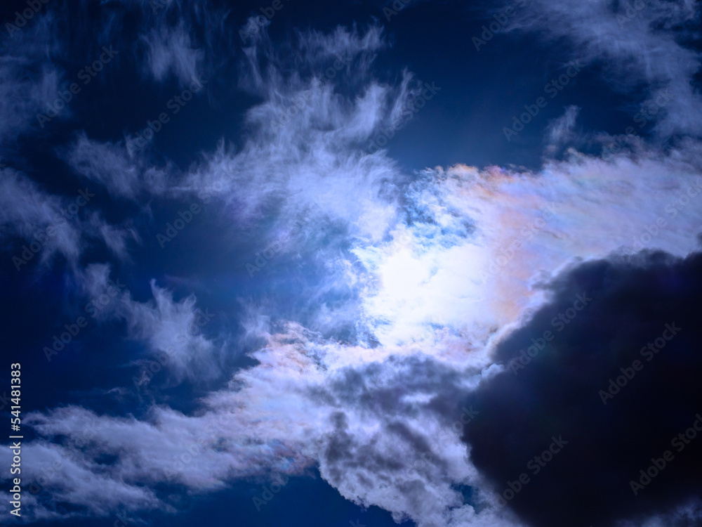 Obraz premium The sun shines through overcast dark-blue clouds