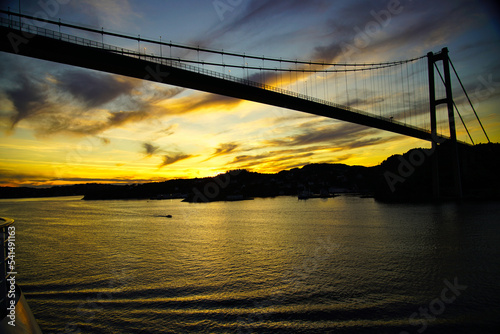 Einfahrt in der Morgendämmerung mit einem Kreuzfahrtschiff unter der Askøy-Brücke nach Bergen, Norwegen photo