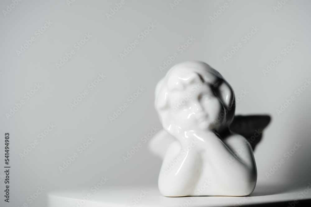 Porcelain ceramic angkle toy white on white background with empty space. Religious and holiday concept. Porcelain ceramic angkle toy white on white background with empty space. Religious and holiday concept.