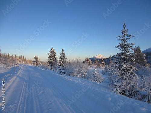 Snow covered road and Himingen in the Lifjell mountain plateau in the Mid-Telemark region, Norway. Himingen is a 1066m high summit and is located in Hjartdal