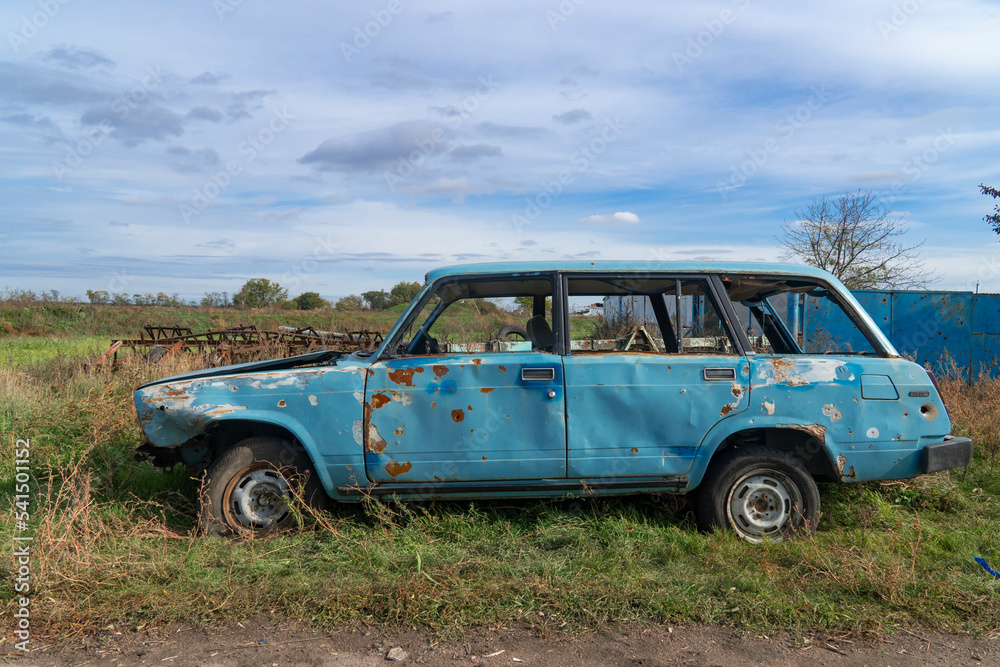 War in Ukraine. 2022 Russian invasion of Ukraine. Countryside. A destroyed civilian car stands on the side of the road. Holes from bullets and splinters on the body of the car War in Ukraine. 2022 Russian invasion of Ukraine. Countryside. A destroyed civilian car stands on the side of the road. Holes from bullets and splinters on the body of the car