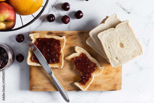 Delicious toasts with jam on cutting board photo