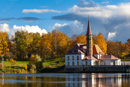 Priory Palace on the shore of the lake in Gatchina near St. Petersburg in the autumn afternoon, the castle against the background of the autumn forest
