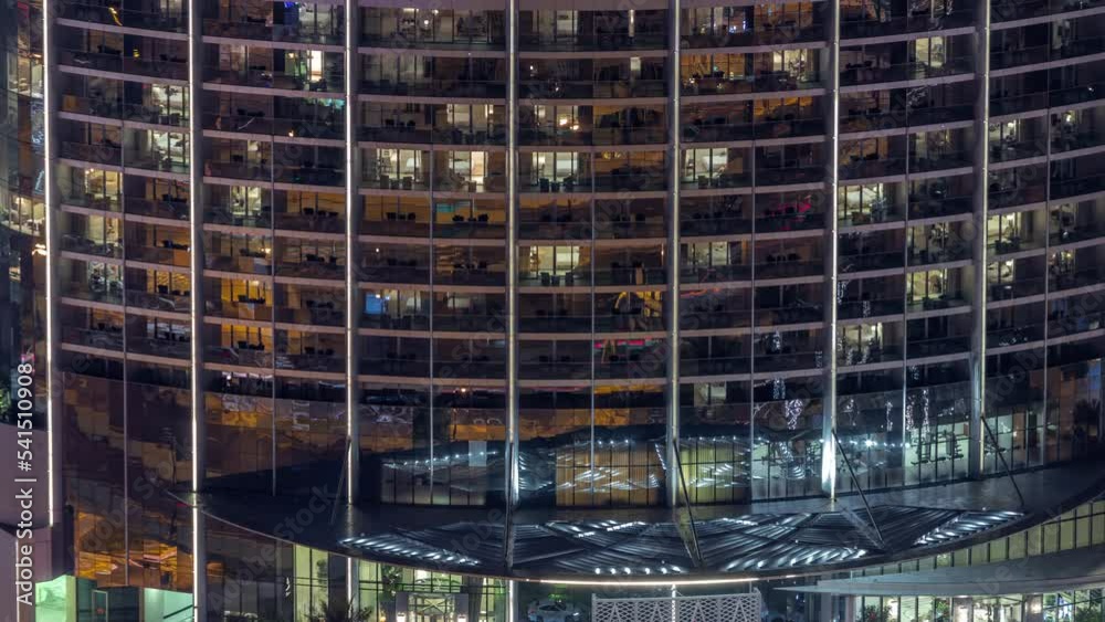 Illuminated panoramic windows in apartments of a high class building at ...