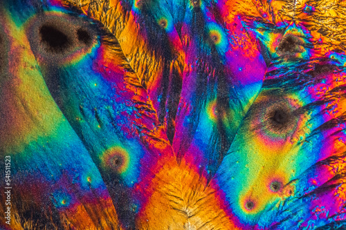 Extreme macro photograph of Vitamin C crystals forming abstract modern art patterns, when illuminated with polarized light, under a microscope objective with 10x magnification