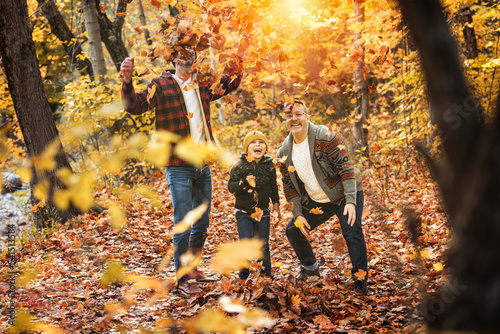 Happy two man couple with adopted child on autumn season