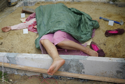 Dead woman lay down under bag covered death body from accident or murder at house of victim with evidence. Horror scene for Halloween.