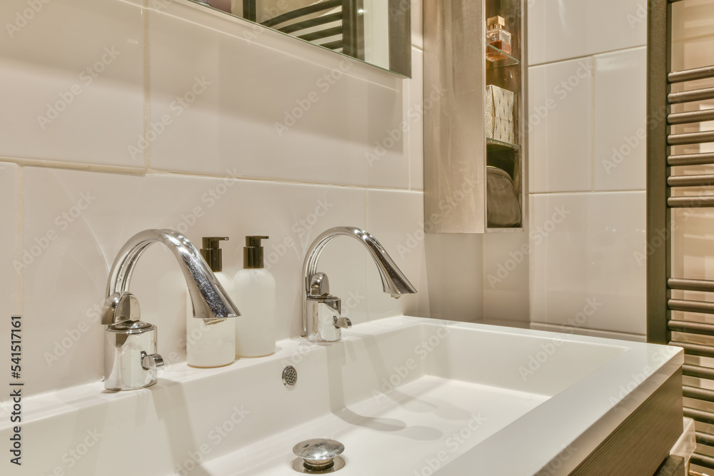 Washbasin with chrome tap and mirror in small lavatory room Washbasin with chrome tap and mirror in small lavatory room