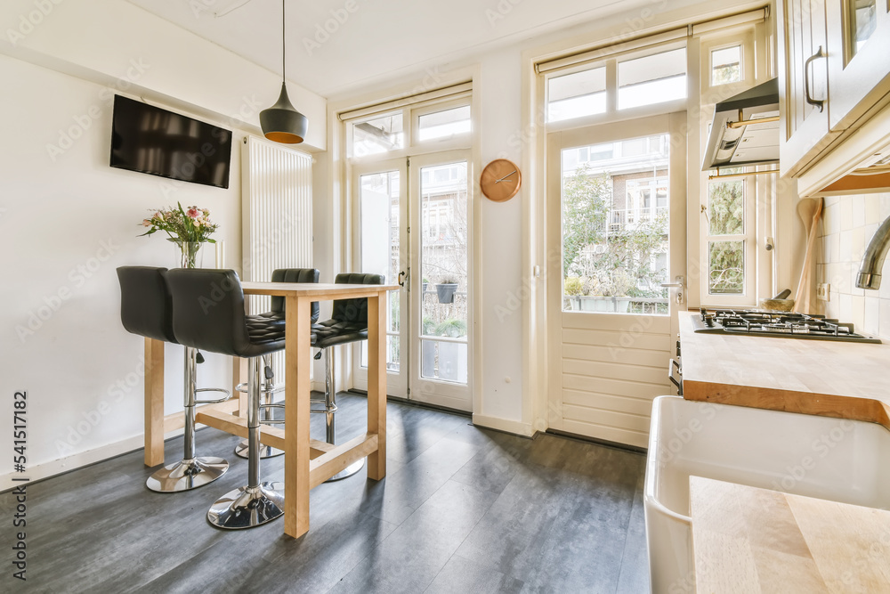 Trendy stools placed at counter in modern kitchen Stock Photo | Adobe Stock