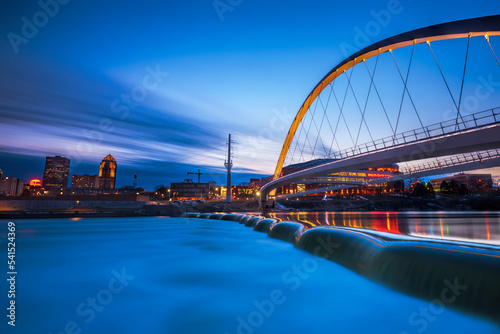 Des Moines River walk bridge reflected in the Des Moines River during blue hour. Des Moines, Iowa.  photo