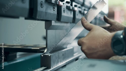 Press operator bending sheet metal. Close up.