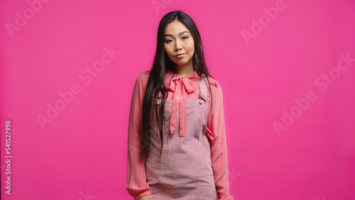 displeased and young asian woman looking at camera isolated on pink © LIGHTFIELD STUDIOS