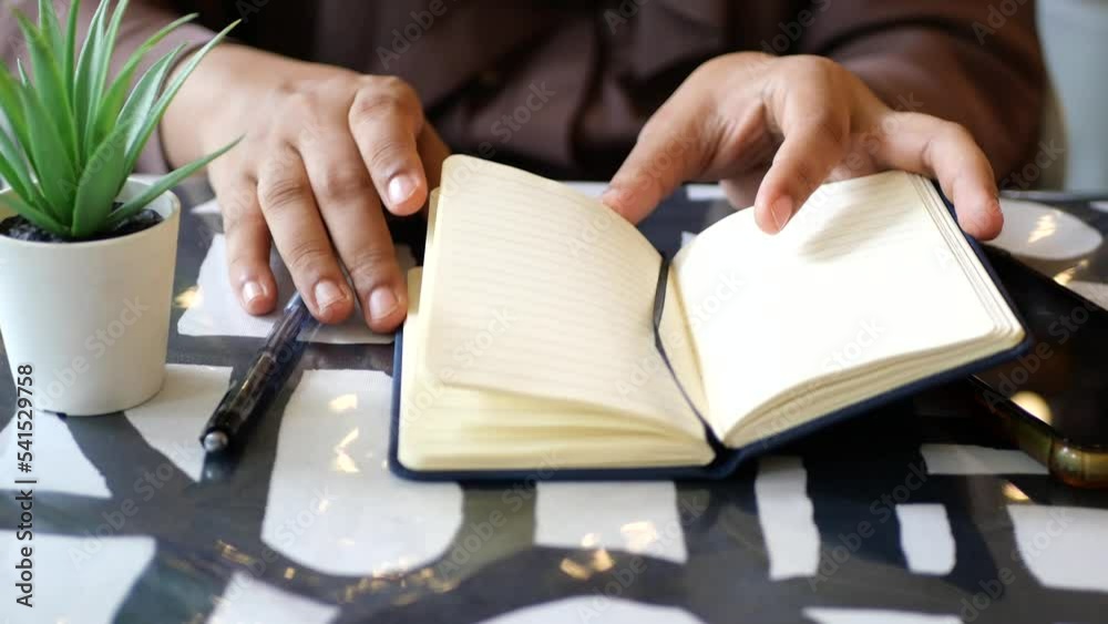  women hand turning a pager of a diary 