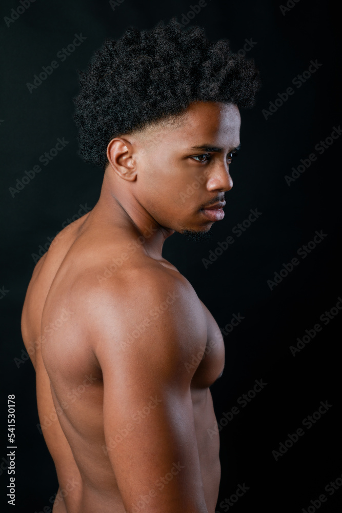 Fototapeta premium Young strong sportsman. Latin athlete portrait. Black background.