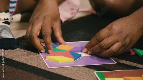 Young Black children, Black girls, Black boy, and Black infant baby playing with building blocks, toys, and train sets