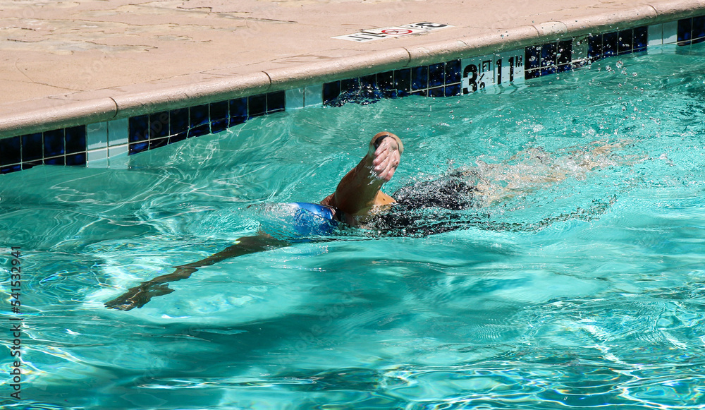 Female swimmer swimming in an outdoor pool