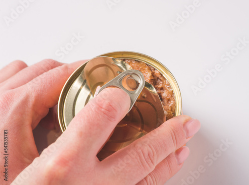 Man's hands opening a aluminum can full of cat or dog food, pate, grinned meat for pet food. Recycle materials, ecological