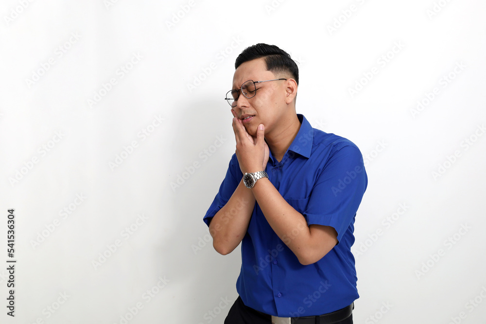 Young asian man standing while suffering from toothache. Isolated on white background with copyspace Young asian man standing while suffering from toothache. Isolated on white background with copyspace