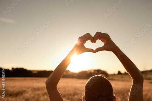 Girl with heart up to the sun Fototapet