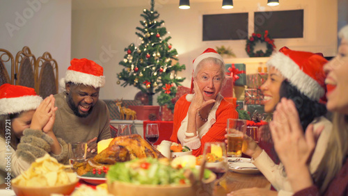 A group of multi ethnic. Portrait of Caucasian and African American black family, woman have a celebration dinner in party on Merry Christmas Eve Xmas on holiday at home.People lifestyle. thanksgiving