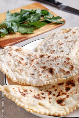 Delicious gourmet flat bread kutabs with herbs and cheese on a plate. photo