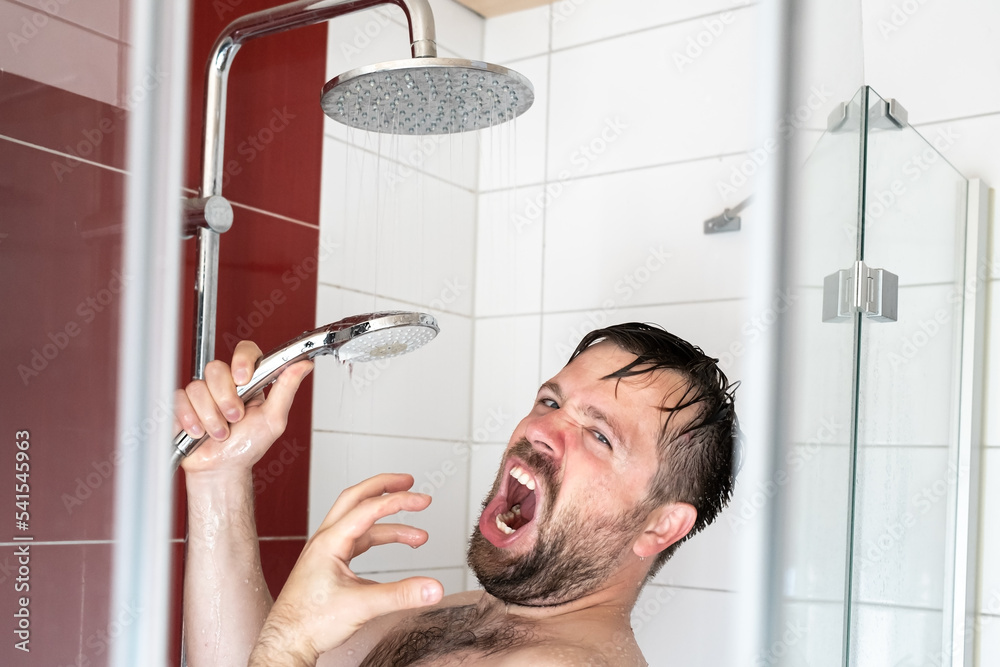 European man singing loudly in the shower using a watering can as a