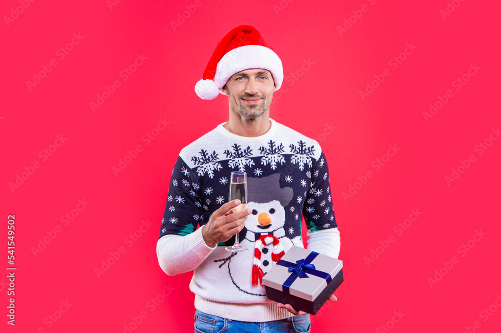 xmas present and cheerful man with champagne. man in xmas santa hat with present and champagne.