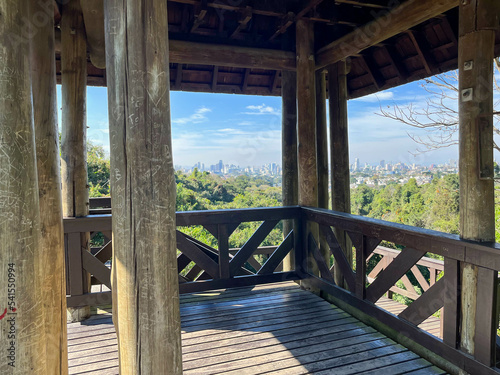 Wooden viewpoint in Bosque do Alemão and buildings in the city of Curitiba in the background. photo
