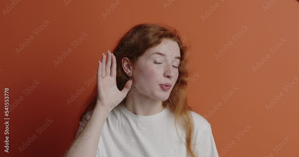 Ginger woman trying to hear isolated. Confused girl keeping hand near ear
