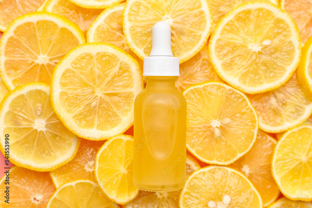 Bottle of vitamin C serum on lemon slices Bottle of vitamin C serum on lemon slices