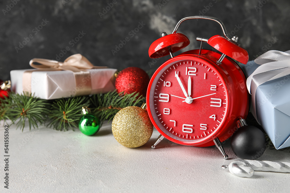 Red alarm clock and Christmas decorations on white table Red alarm clock and Christmas decorations on white table