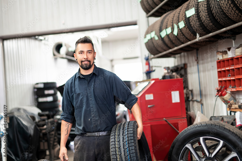 Nice and cool mechanic changing car tire at work Nice and cool mechanic changing car tire at work
