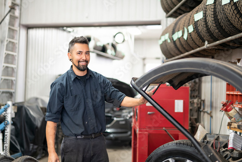 Nice and cool mechanic changing car tire at work