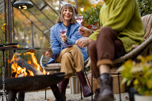 Photography Young stylish couple grilling food and warming up while sitting together by the