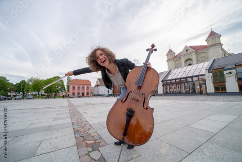 A female musician with a cello on the street
