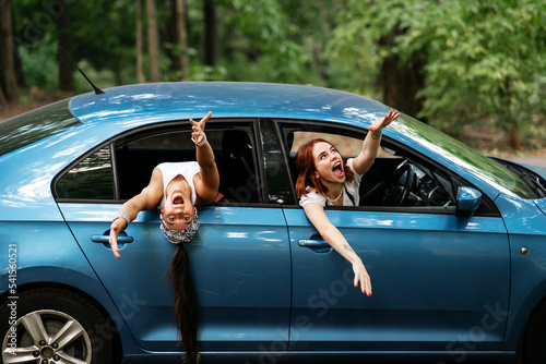 Two girlfriends fool around and laughing together in a car © teksomolika