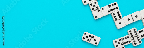 Domino pieces on turquoise blue background with copy space. Flat lay minimalist photo of some domino bones.