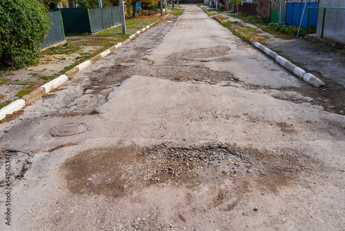 The road is in disrepair with potholes. Background with selective focus as copy space