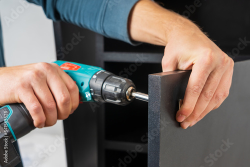 Wallpaper Mural Installation of the handle on the front door when assembling furniture. Selective focus with blurred background Torontodigital.ca