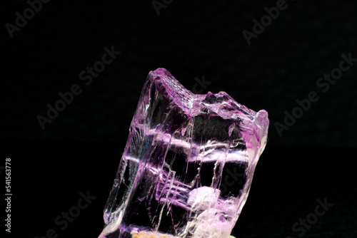 Macro-focused Grade A high-quality pink and violet fully transparent and clear raw uncut Kunzite crystal stone isolated on a black background surface photo
