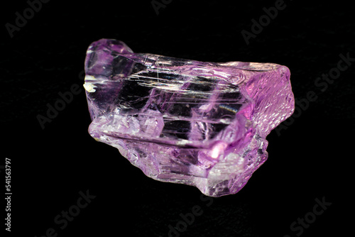 Macro-focused Grade A high-quality pink and violet fully transparent and clear raw uncut Kunzite crystal stone isolated on a black background surface photo