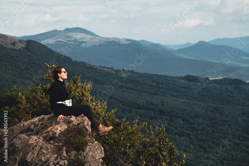 Młoda dziewczyna odpoczywa w górach w czasie wakacji siedząc na skale na szlaku prowadzącym na Połoninę Wetlińską, Bieszczady, Polska © Przemysław Głowik