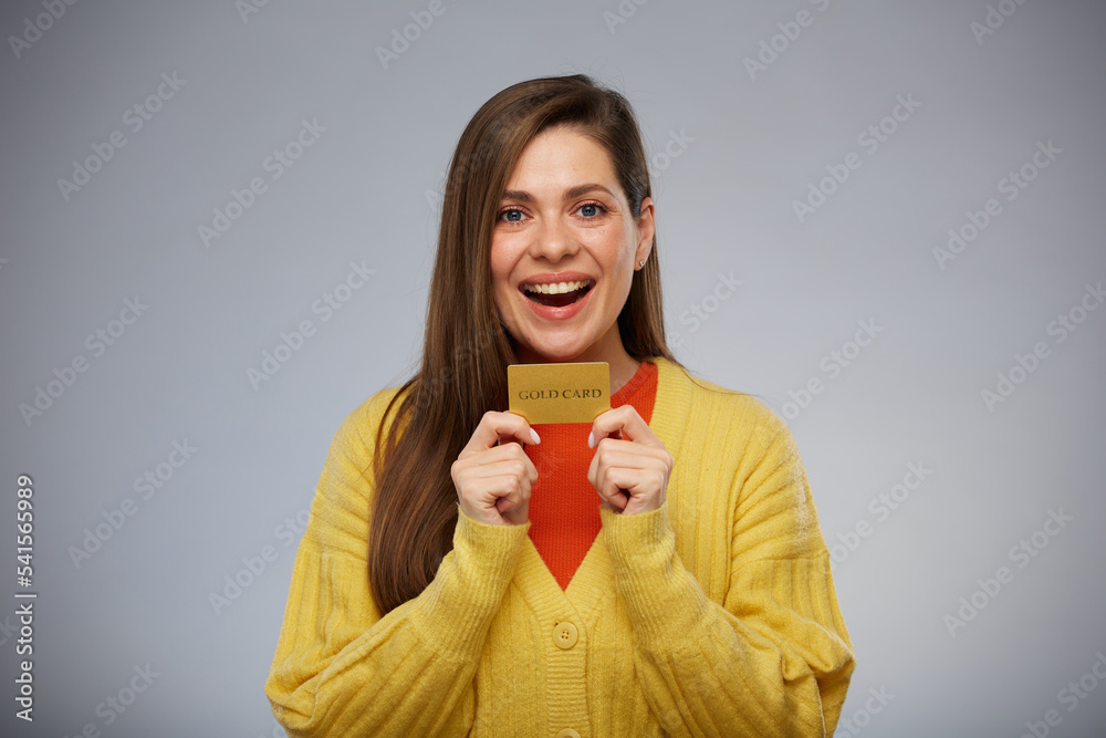 Smiling woman in yellow holding credit card and ready for payment. Isolated female advertising portrait. Smiling woman in yellow holding credit card and ready for payment. Isolated female advertising portrait.