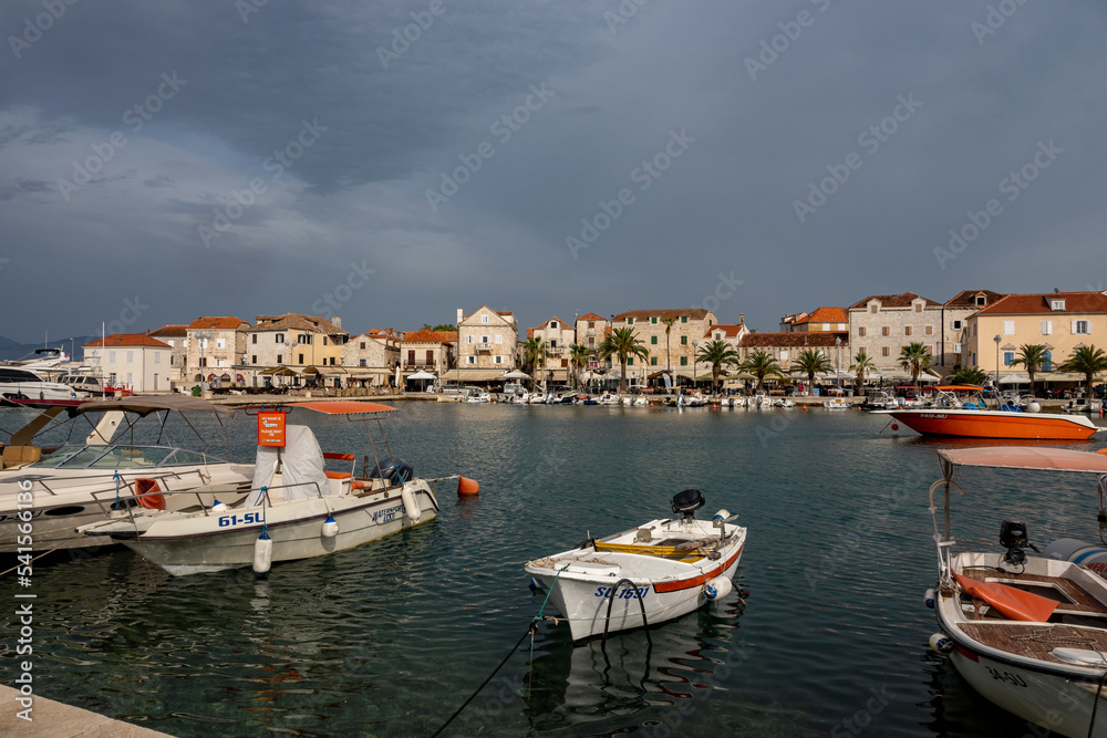 Beautiful stone houses at the town of Supetar, Croatia, located on Brac island with approaching storm in distance