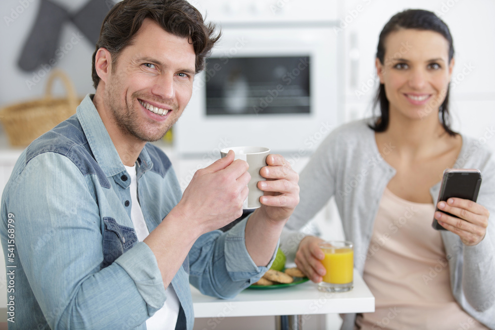 beautiful young couple having breakfast woman looking at mobile phone beautiful young couple having breakfast woman looking at mobile phone