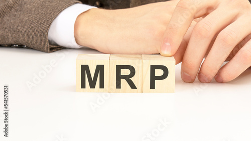 hand holding wooden cube blocks with text mrp - monthly recurring revenue - on white table background. financial, marketing and business concepts photo