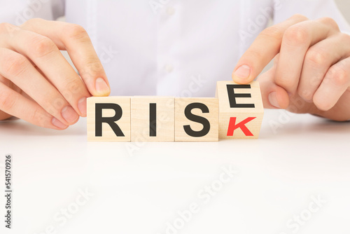 wooden cube with flip over block RISE to RISK word. business, management, inspiration to success ideas and goals.