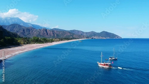 Two yachts warm up in the Mediterranean near ancient Olympus. The photo shows Takhtala mountains and the blue sea and a sandy beach. photo